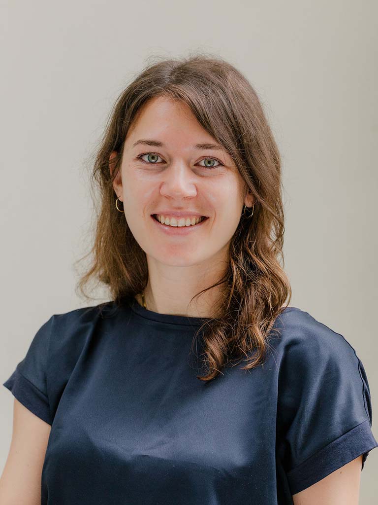 Ein Portrait von einer Frau mit braunen Haaren die lächelt